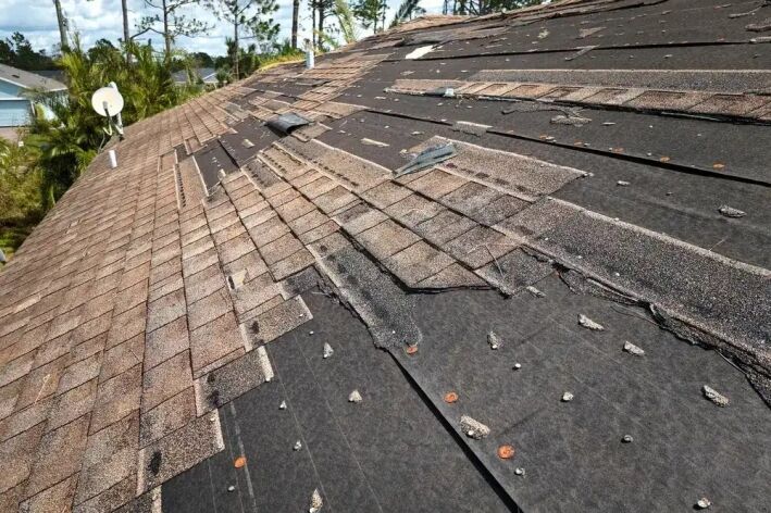 Wind,Damaged,House,Roof,With,Missing,Asphalt,Shingles,After,Hurricane